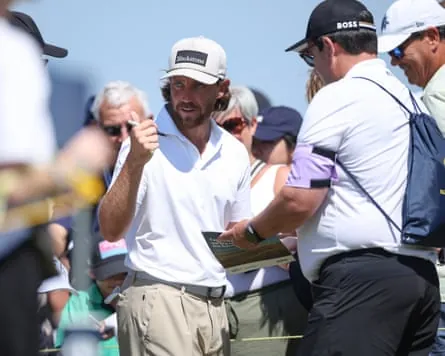 The golfer Tommy Fleetwood signs autographs for fans at Royal Birkdale during practice for the Open.
